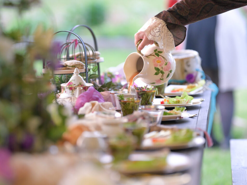 Tea being poured into a cup at a table